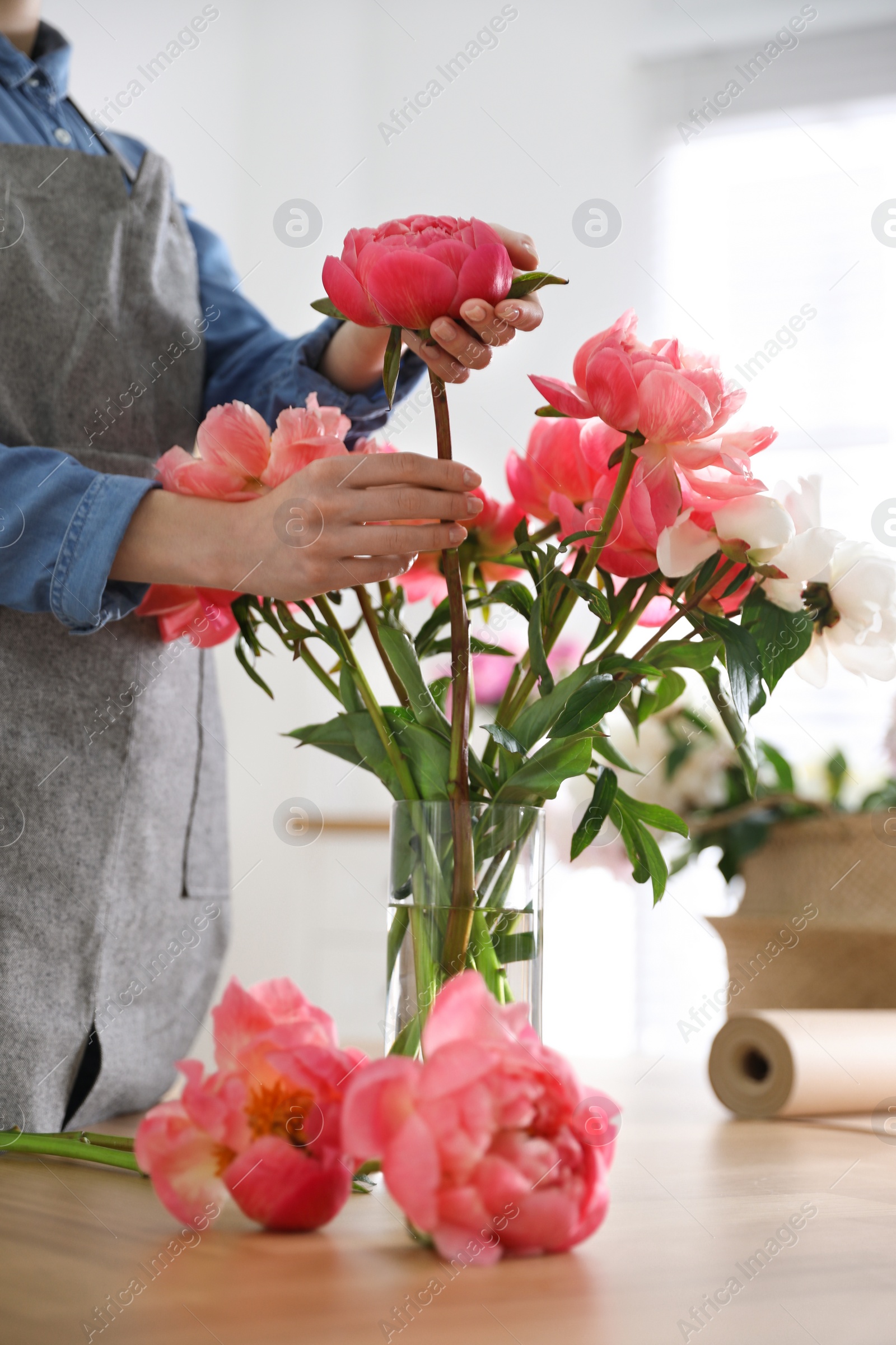 Photo of Florist making beautiful peony bouquet at table, closeup