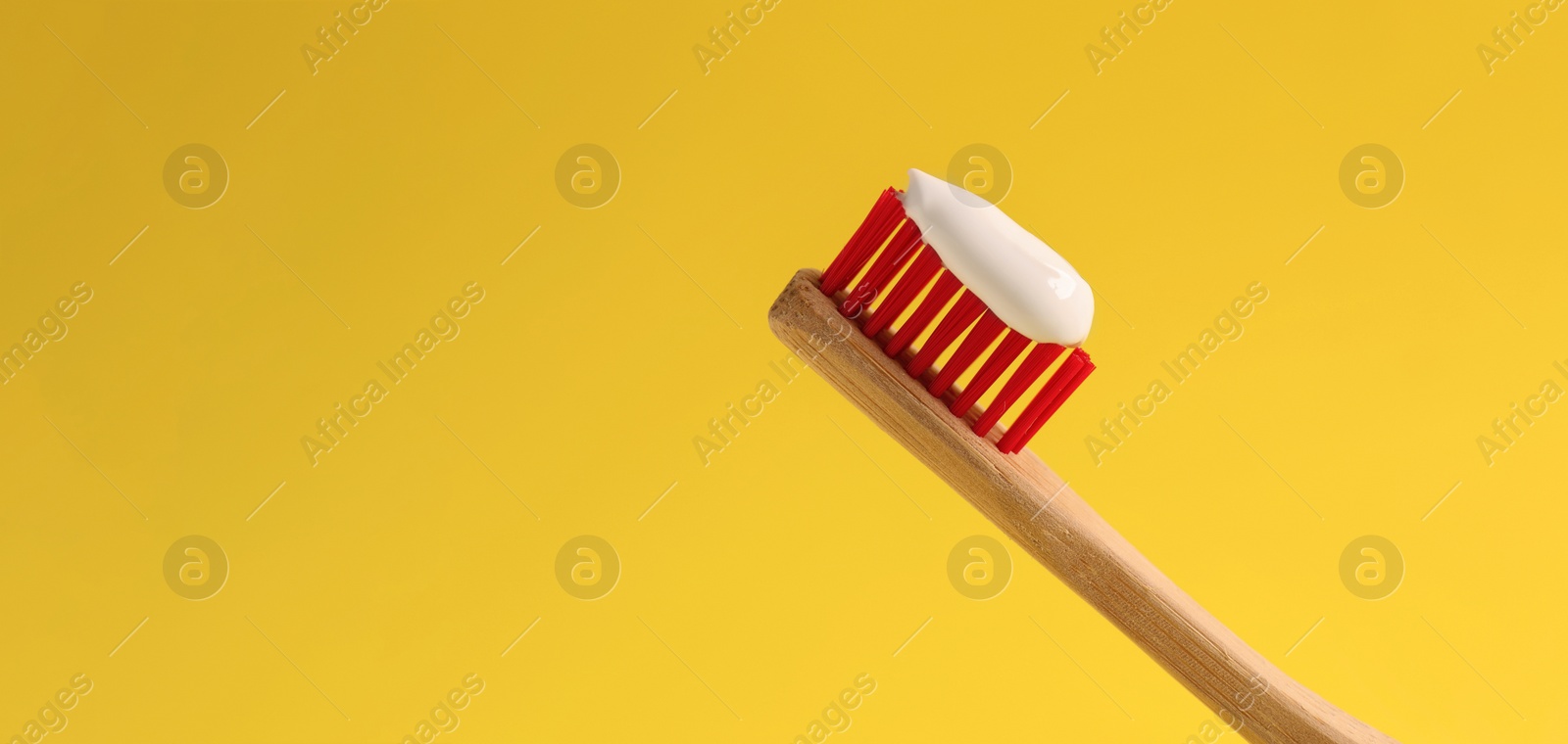 Image of Brush with toothpaste on yellow background, space for text. Banner design