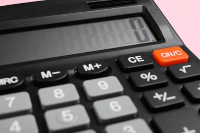 Photo of Calculator on pink background, closeup. Office stationery