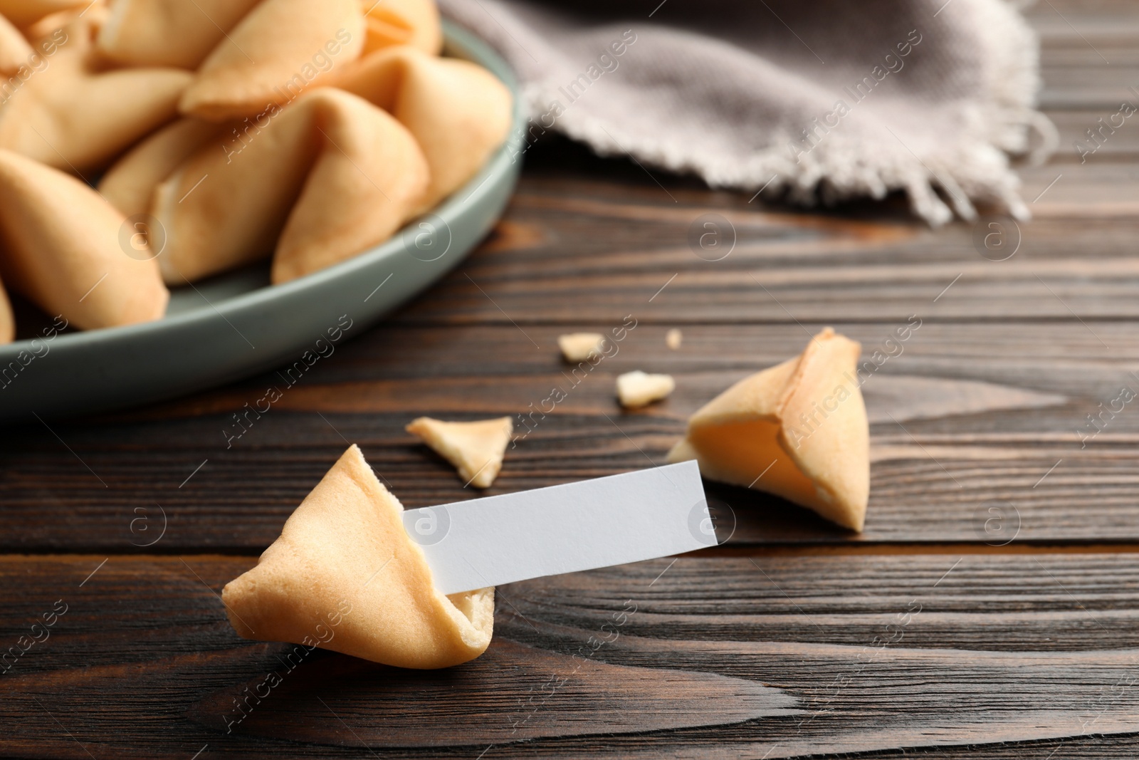 Photo of Tasty fortune cookies and paper with prediction on wooden table, space for text