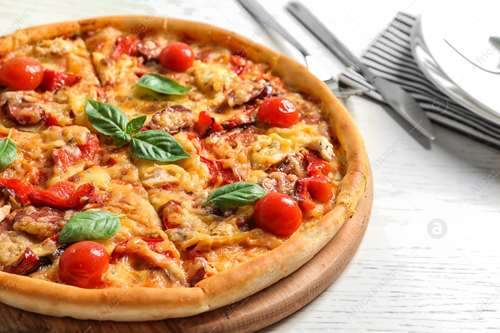 Photo of Delicious pizza with tomatoes and sausages on table