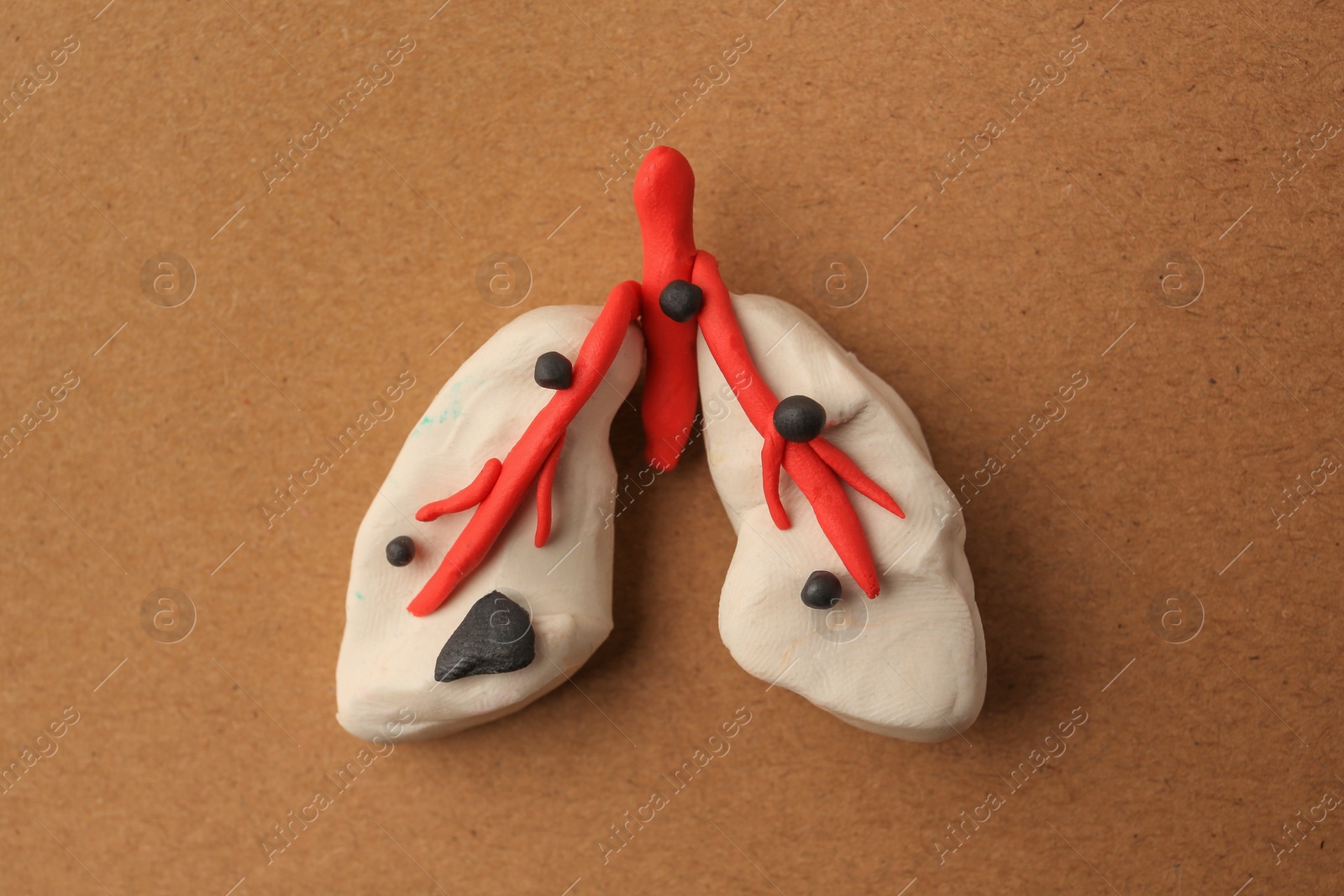 Photo of Human lungs made of plasticine on light brown background, top view. Respiratory disease concept