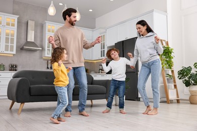 Happy family dancing and having fun at home, low angle view