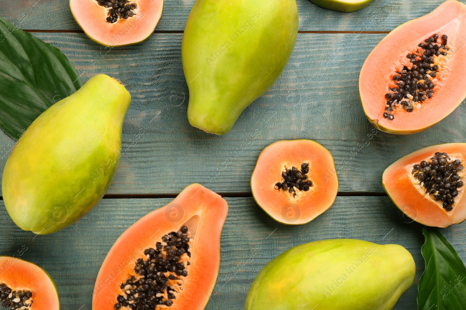 Photo of Fresh ripe papaya fruits on wooden table, flat lay