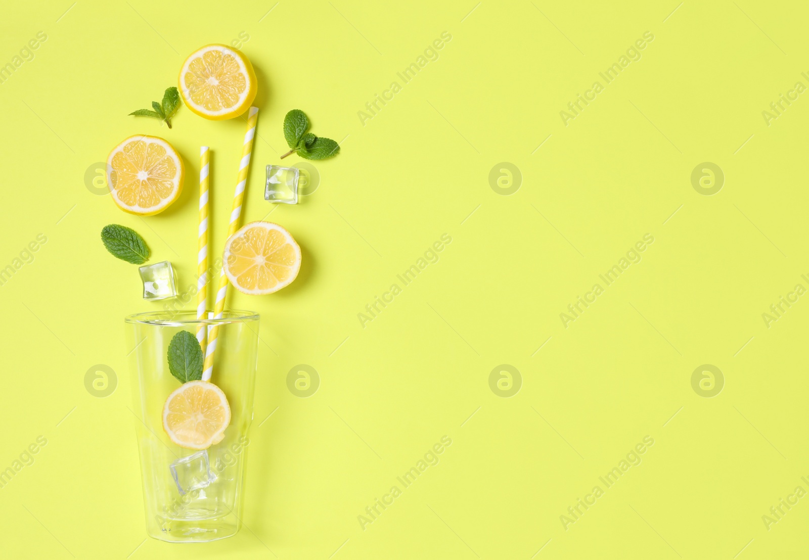 Photo of Creative lemonade layout with citrus slices, ice and mint on yellow background, flat lay. Space for text