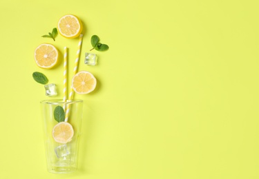 Photo of Creative lemonade layout with citrus slices, ice and mint on yellow background, flat lay. Space for text