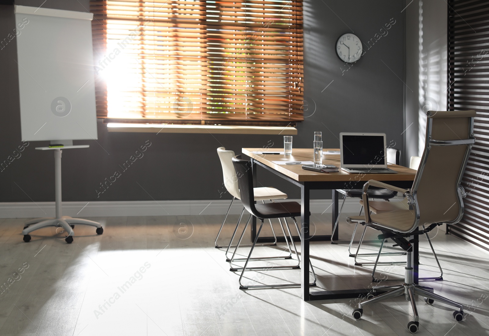 Photo of Stylish office interior with wooden table and flipchart