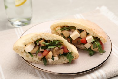 Delicious pita sandwiches with cheese, mushrooms tomatoes and arugula on table