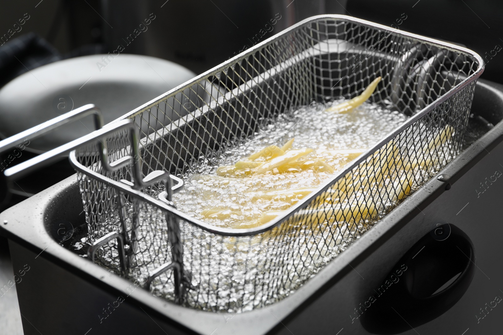 Photo of Cooking delicious french fries in hot oil