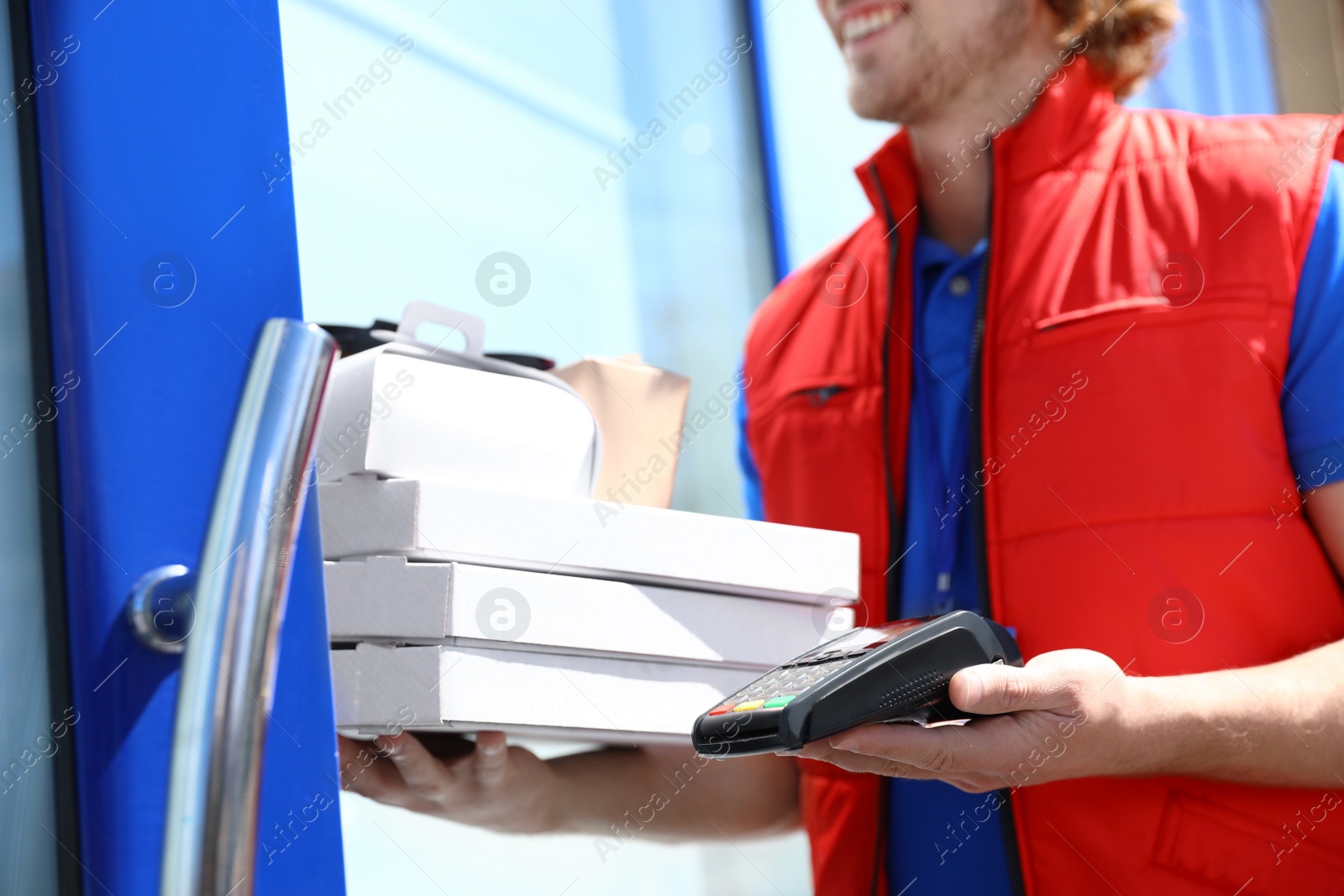 Photo of Male courier with terminal delivering food to door, closeup