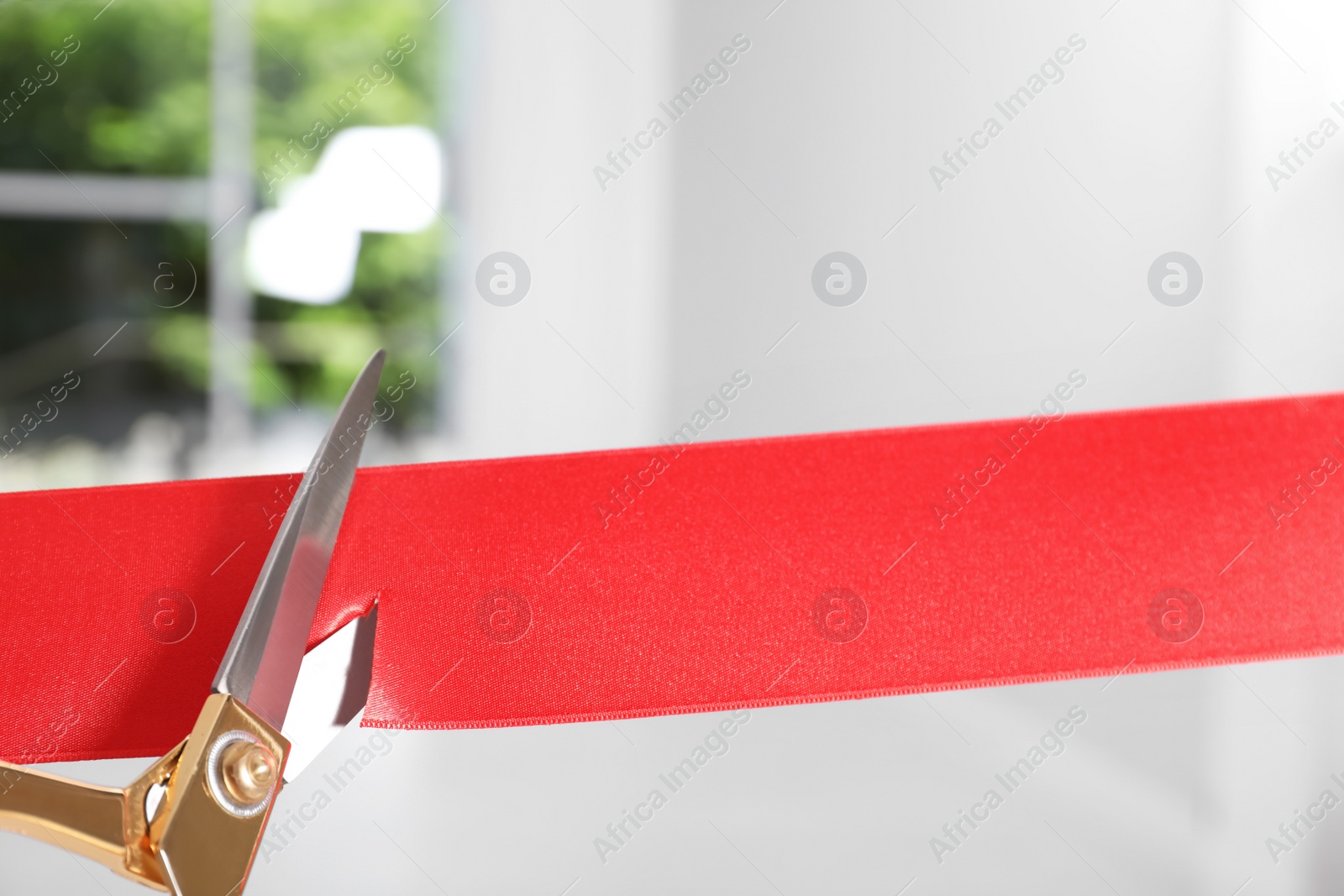 Photo of Ribbon and scissors on blurred background. Ceremonial red tape cutting