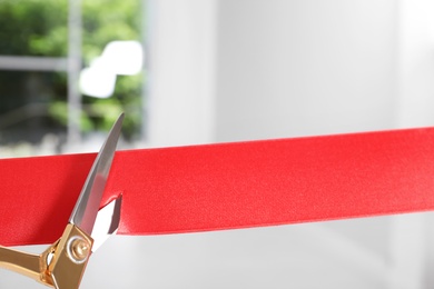 Ribbon and scissors on blurred background. Ceremonial red tape cutting