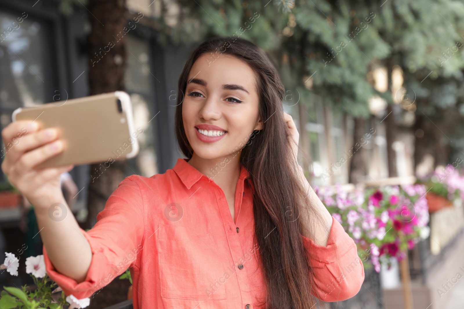 Photo of Beautiful young woman taking selfie outdoors on sunny day