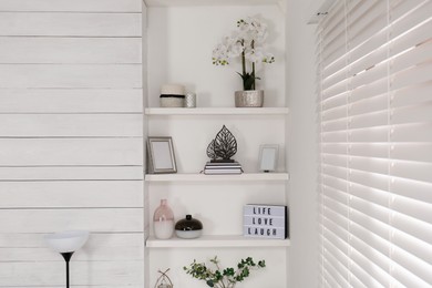 Photo of Wall shelves with beautiful decor elements indoors. Interior design