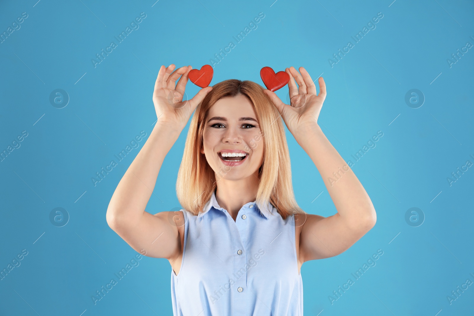 Photo of Portrait of beautiful woman holding decorative hearts on color background