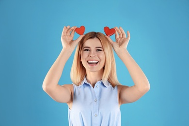 Photo of Portrait of beautiful woman holding decorative hearts on color background