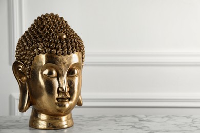 Photo of Buddha statue on white marble table. Space for text