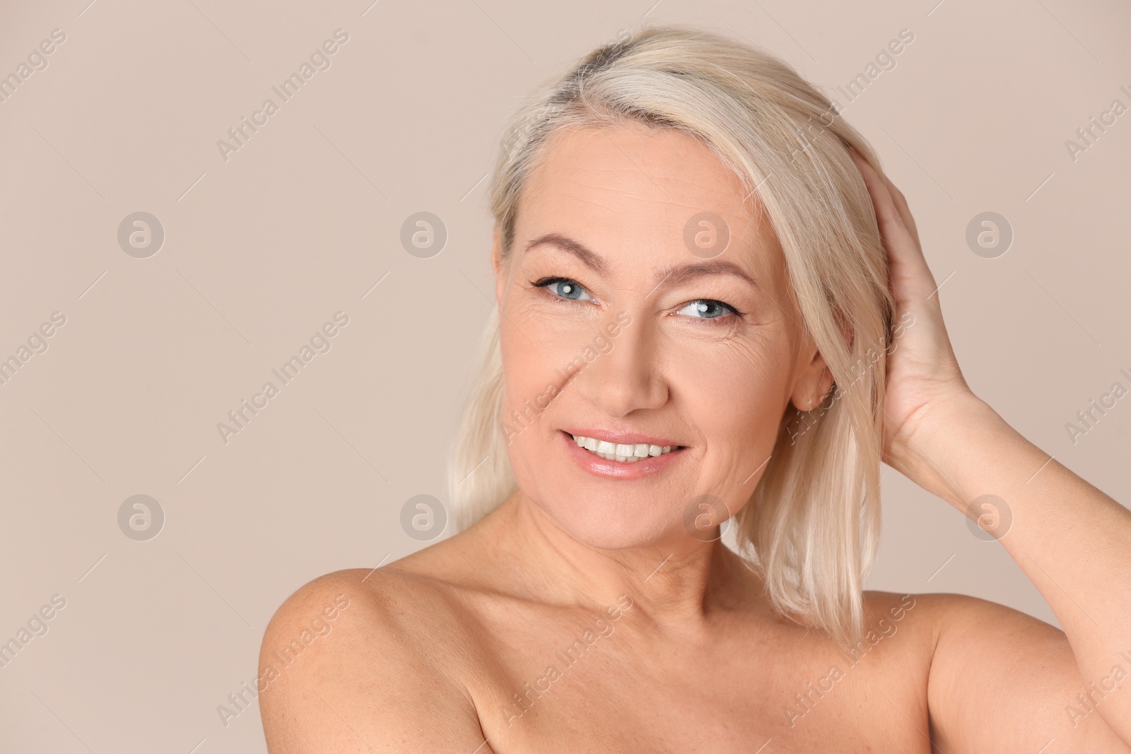 Photo of Portrait of beautiful mature woman on beige background