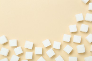 White sugar cubes on beige background, top view. Space for text