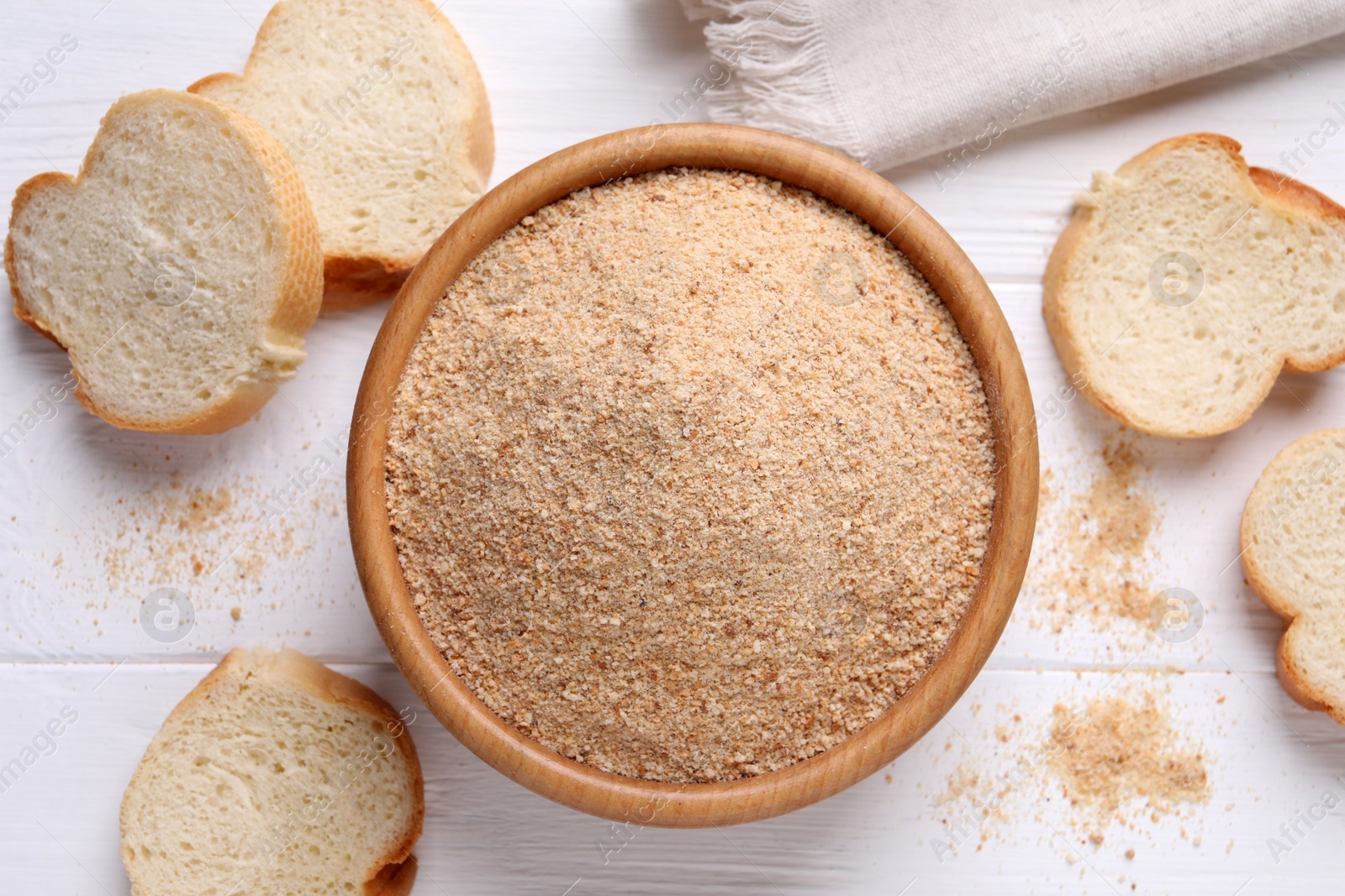 Photo of Fresh breadcrumbs on white wooden table, flat lay