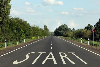 Image of New beginnings. Word Start on asphalt road outdoors
