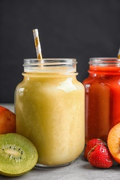 Photo of Delicious juices and fresh ingredients on grey table