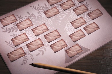 Blank family tree and pencil on wooden table, closeup