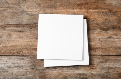 Photo of Stack of blank paper sheets for brochure on wooden background, top view. Mock up