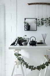 Stylish room decorated with beautiful green eucalyptus branches