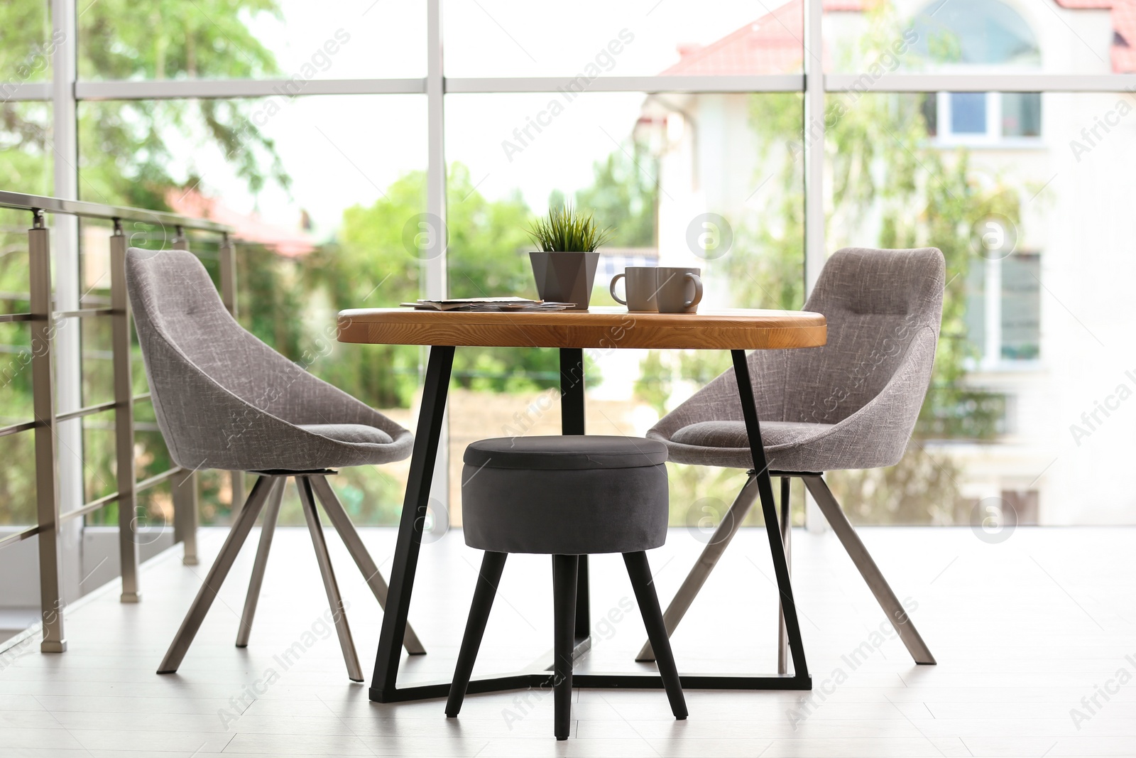 Photo of Stylish room interior with round table and comfortable chairs