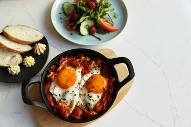 Tasty Shakshouka served on white marble table, flat lay. Space for text