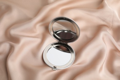 Photo of Grey cosmetic pocket mirror on rose gold fabric