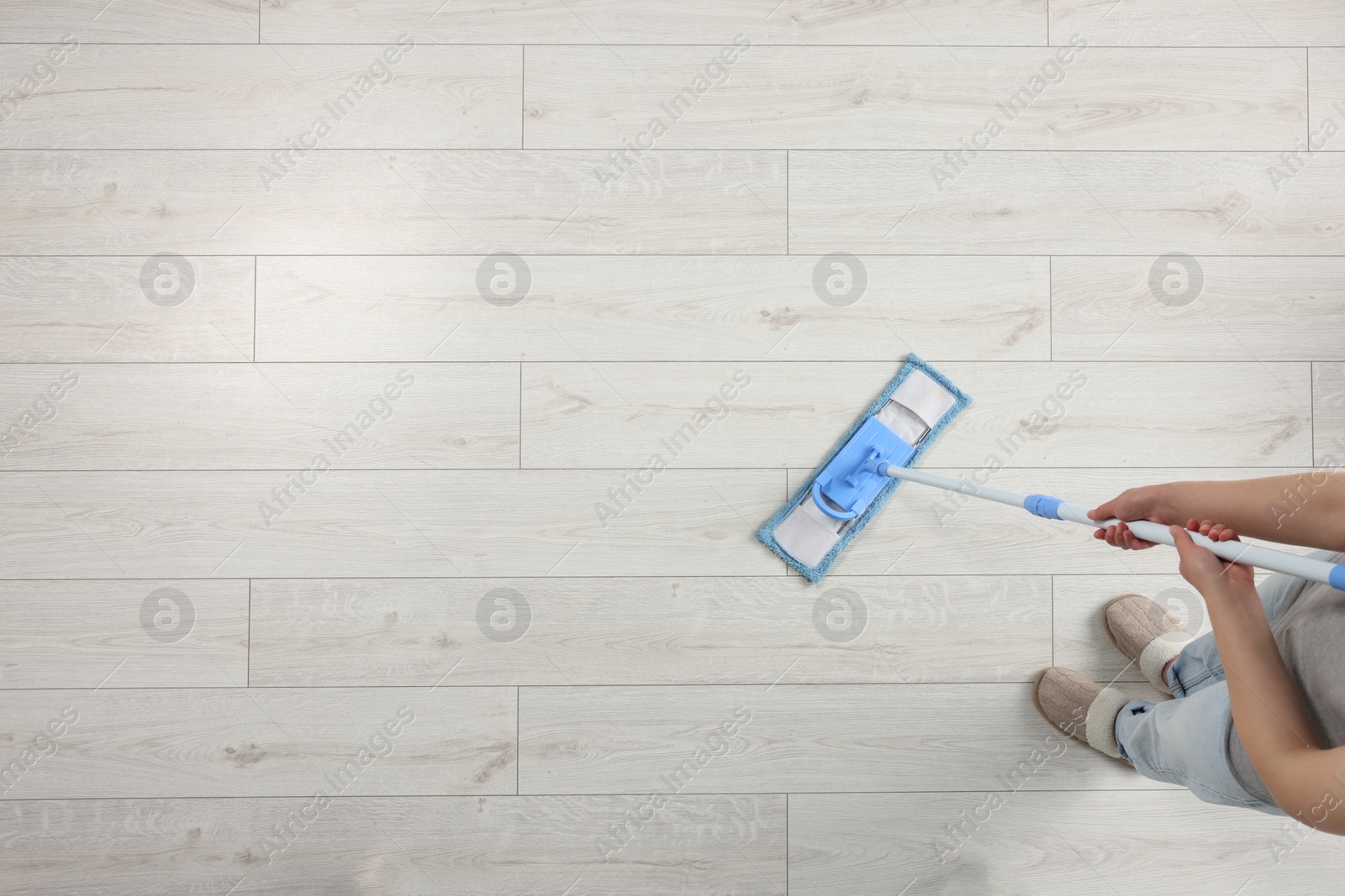 Photo of Woman mopping wooden floor, top view. Space for text