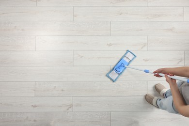 Woman mopping wooden floor, top view. Space for text