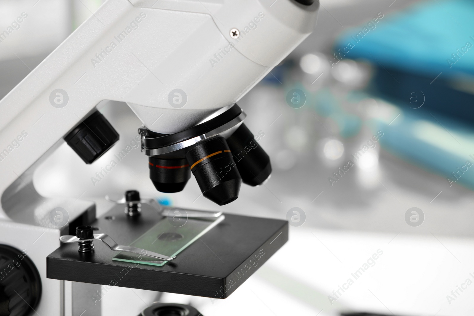 Photo of Modern medical microscope with glass slide on blurred background, closeup. Laboratory equipment