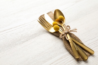 Photo of Cutlery decorated for autumn table setting on white wooden background, space for text