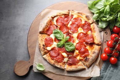 Tasty pepperoni pizza and ingredients on grey table, top view