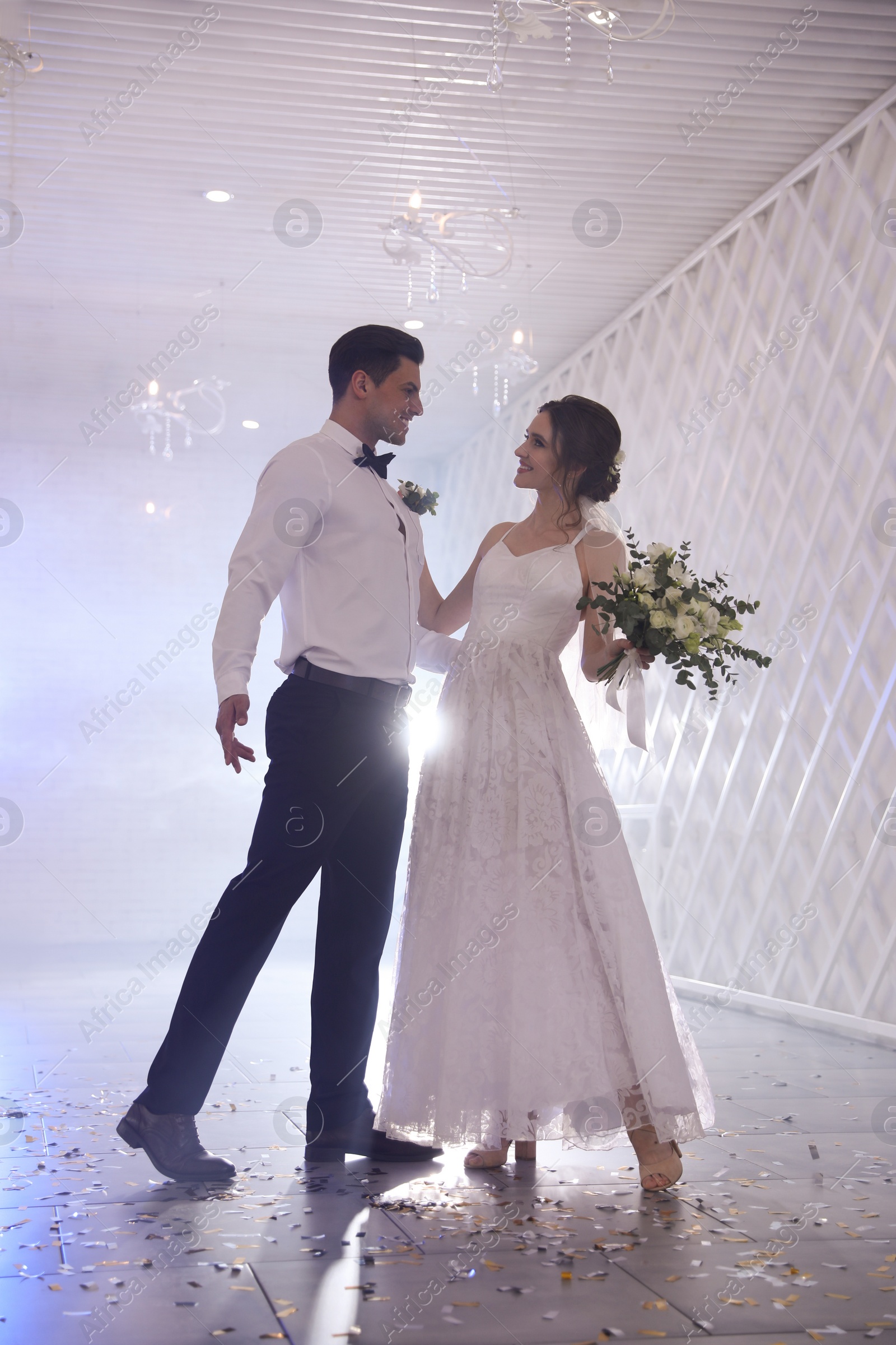 Photo of Happy newlywed couple dancing together in festive hall