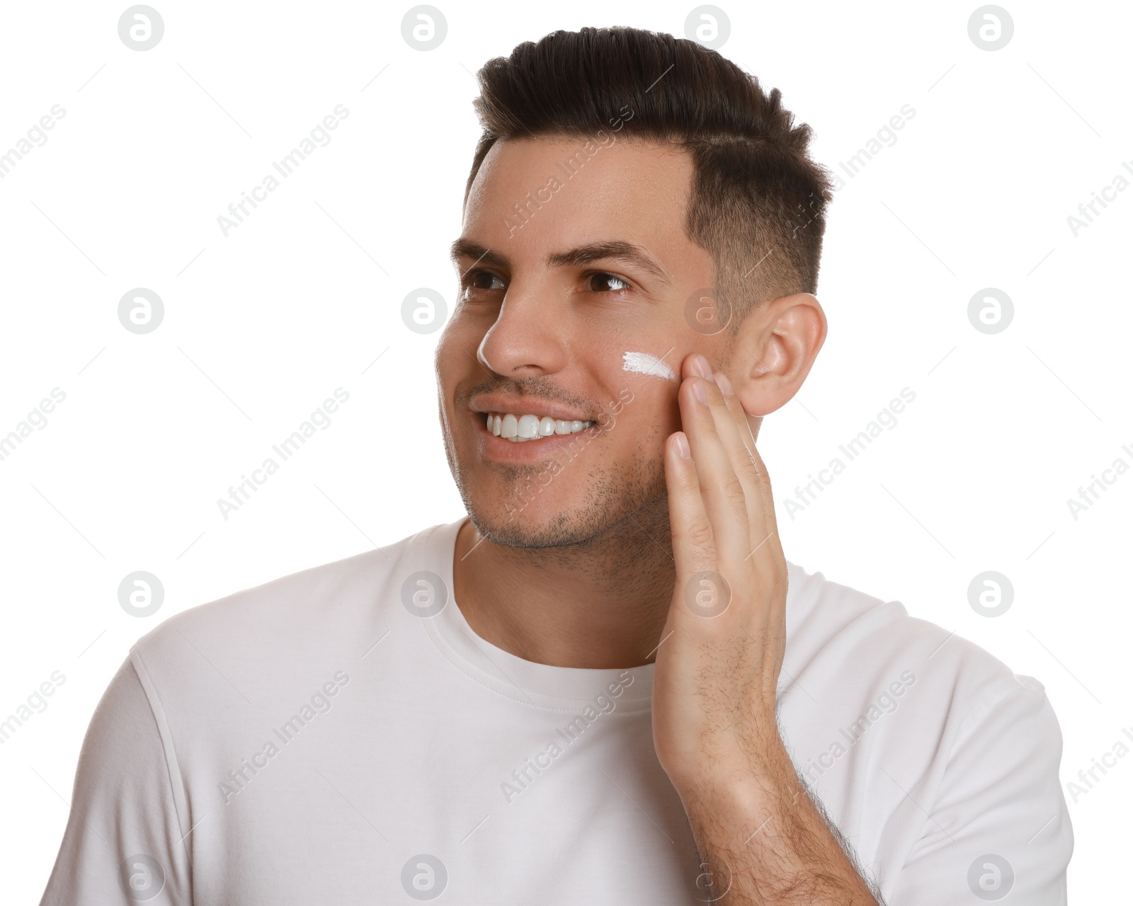 Photo of Handsome man applying face cream on white background