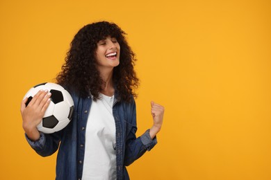 Happy fan with soccer ball celebrating on yellow background, space for text