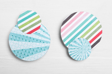 Photo of Big and small colorful paper circles on white wooden background, flat lay. Pareto principle concept