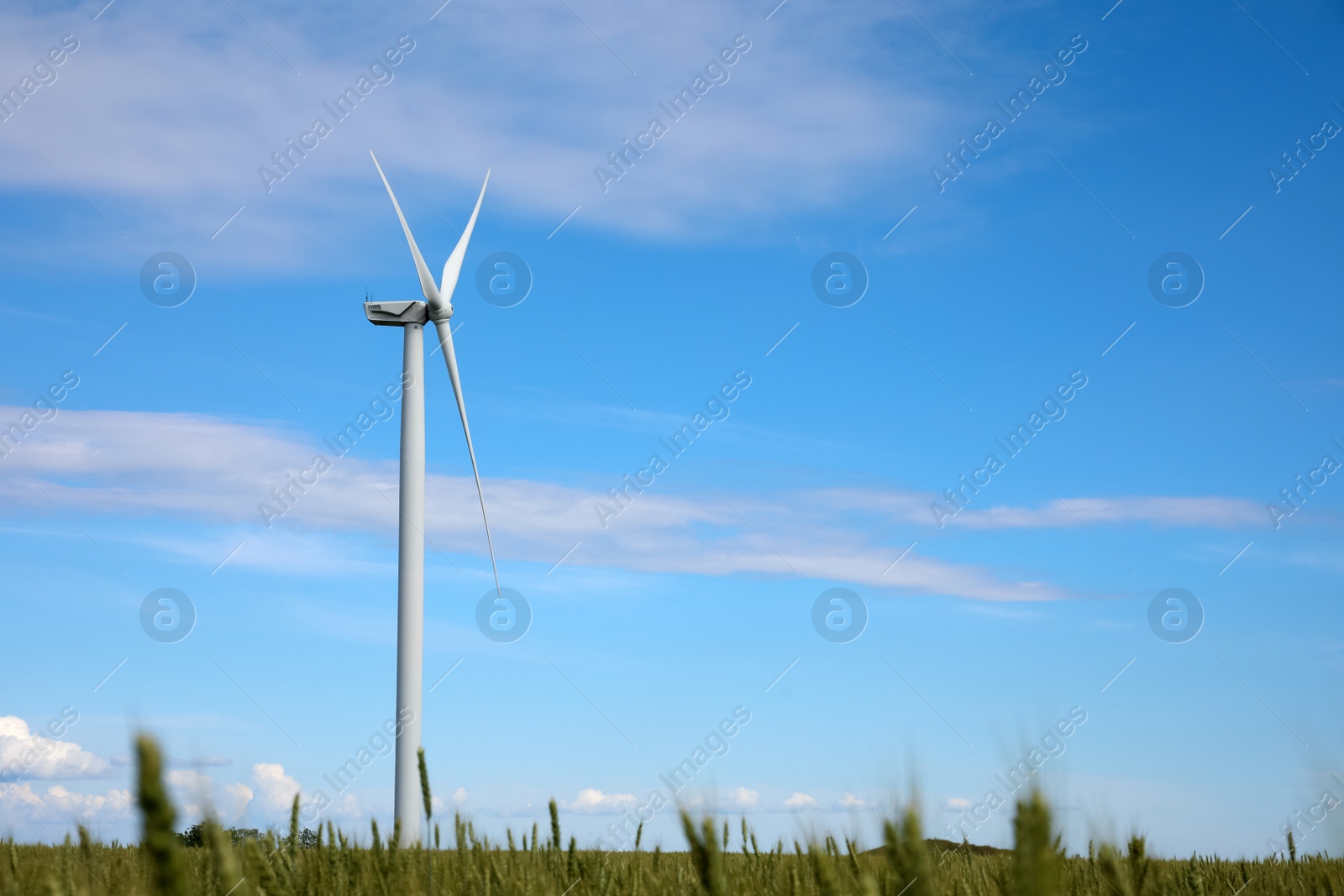 Photo of Beautiful view of field with wind turbine. Alternative energy source