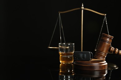 Photo of Car key, gavel, alcohol near scales of justice on black table, space for text. Dangerous drinking and driving