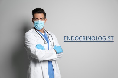 Endocrinologist in protective mask and medical gloves on light grey background