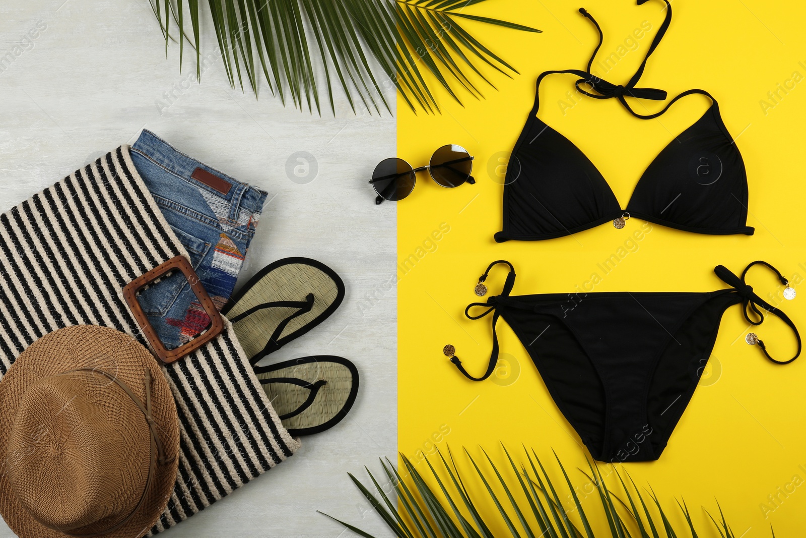 Photo of Flat lay composition with black swimsuit and beach accessories on color background