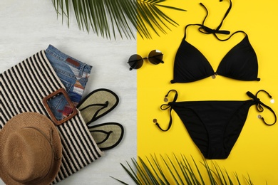 Photo of Flat lay composition with black swimsuit and beach accessories on color background