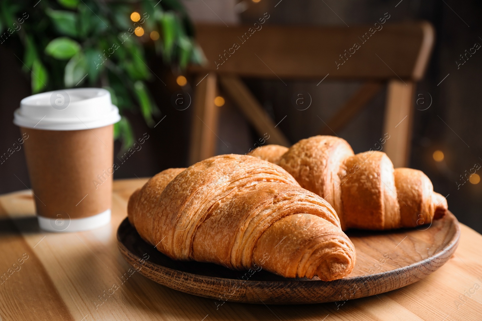 Photo of Tasty fresh croissants and drink on wooden table