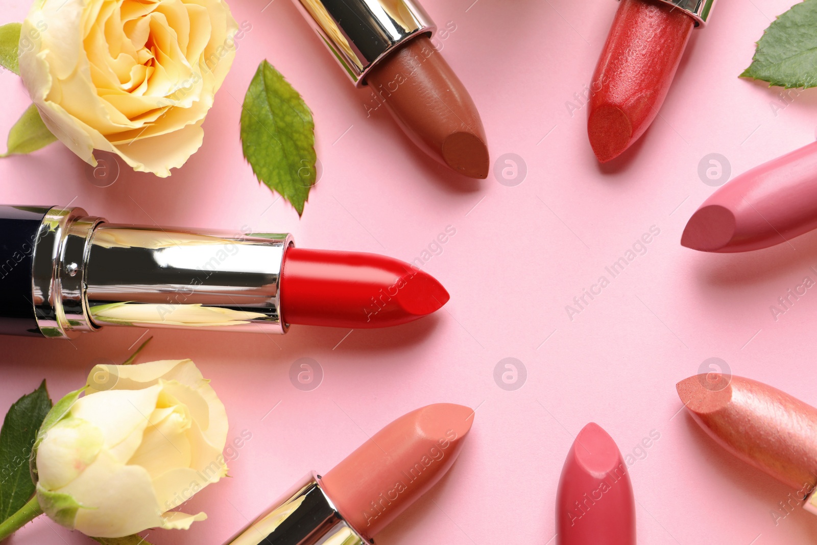 Photo of Flat lay composition with lipsticks and roses on color background