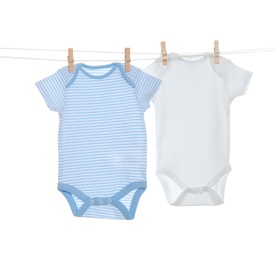 Colorful baby onesies hanging on clothes line against white background. Laundry day