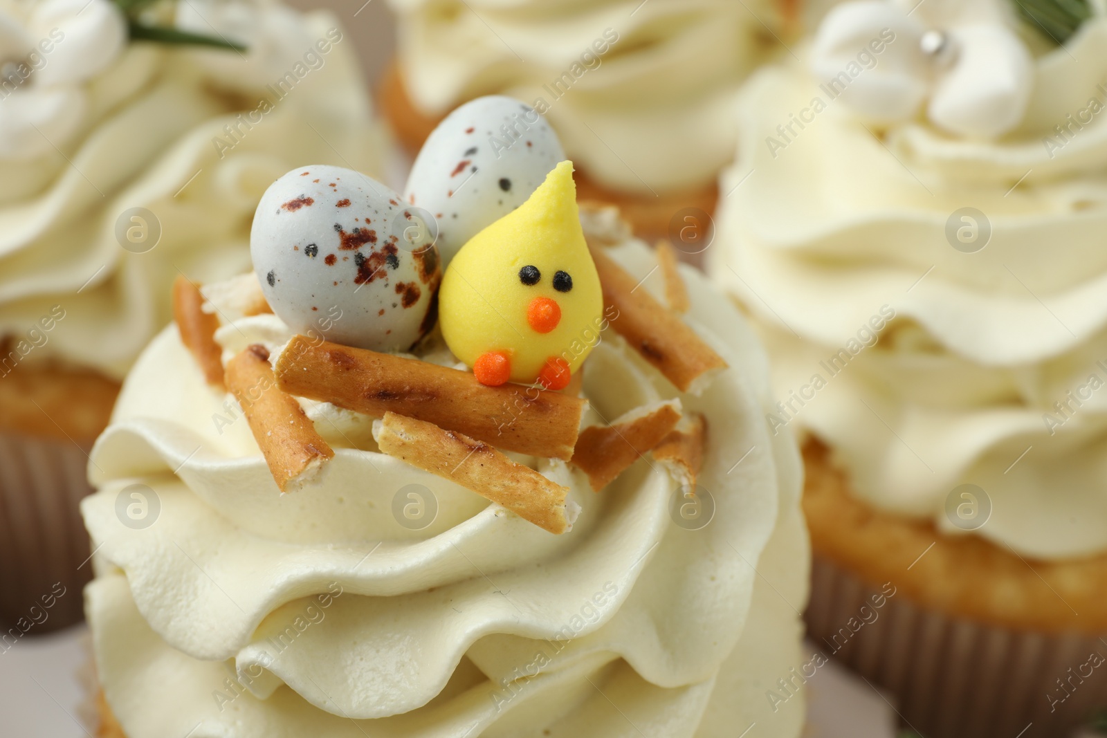 Photo of Tasty Easter cupcakes with vanilla cream, closeup